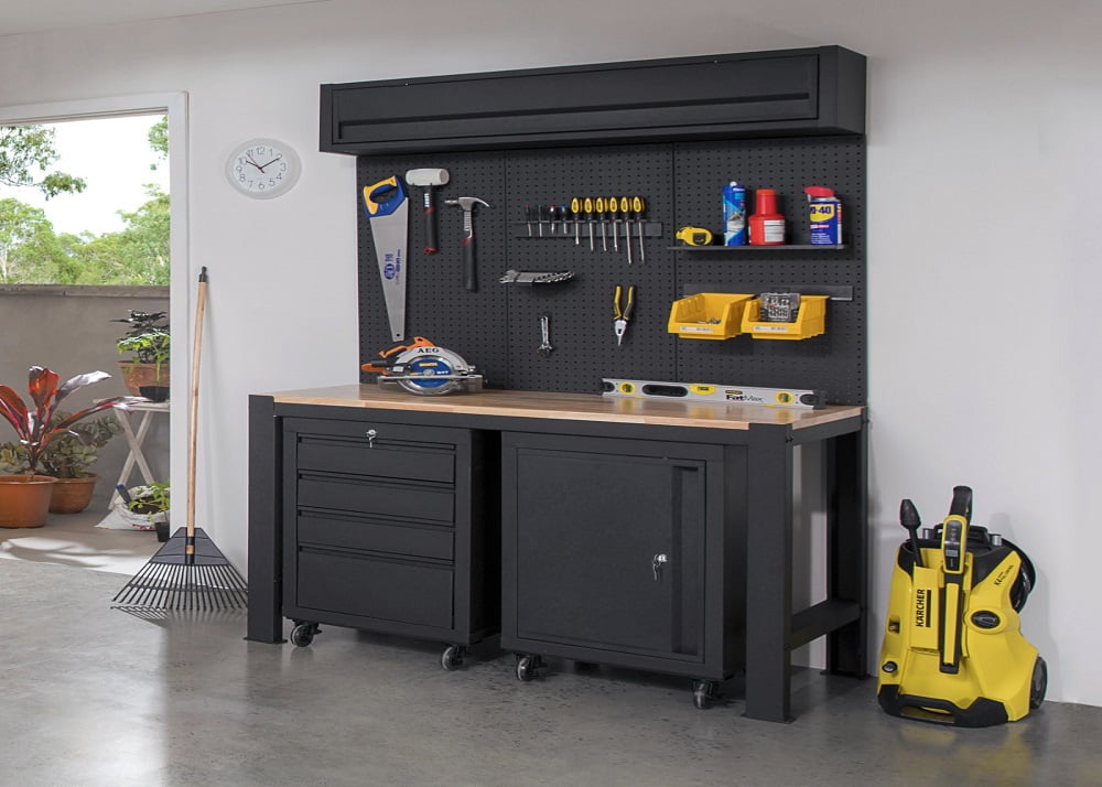 Garage tools and equipment organised using a Pinnacle pegboard, workbench, and cabinets.
